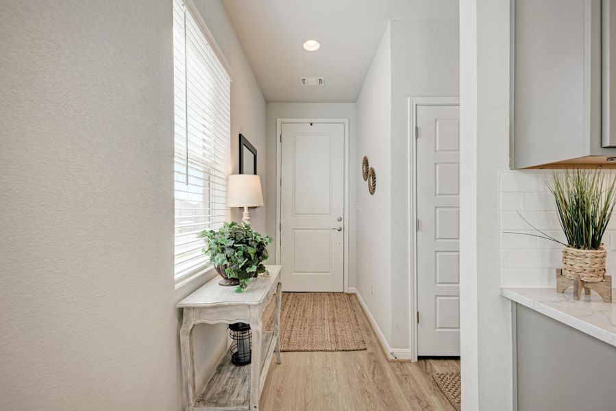 Hall with light wood-type flooring and recessed lighting