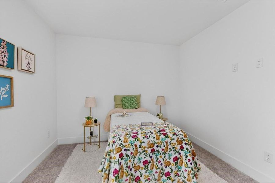 Bedroom featuring baseboards and light carpet Bedroom featuring baseboards and light carpet