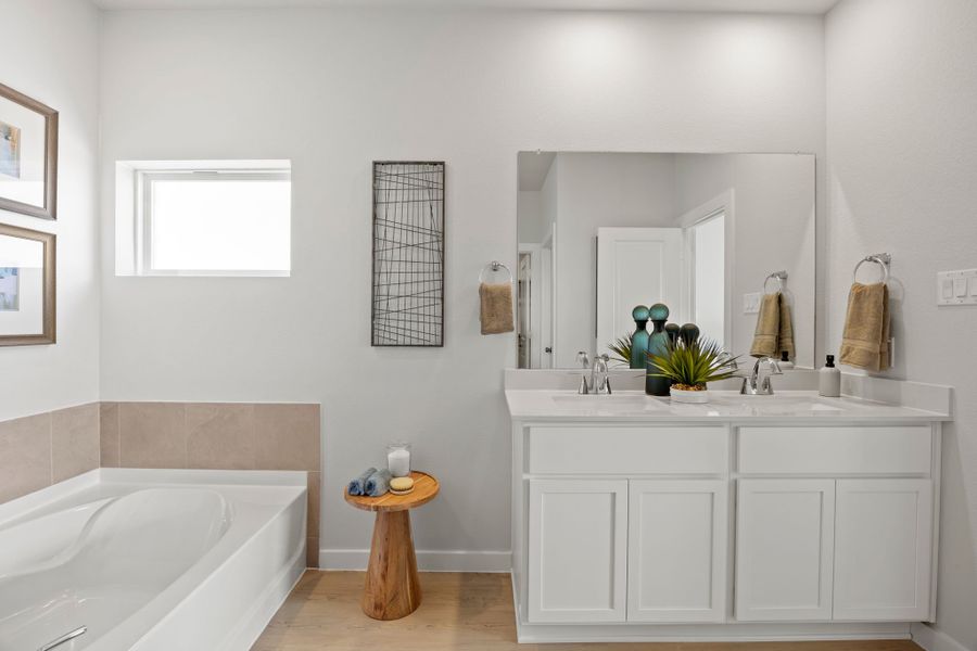 A bathroom with a tub sink and mirror. A bathroom with a tub sink and mirror.