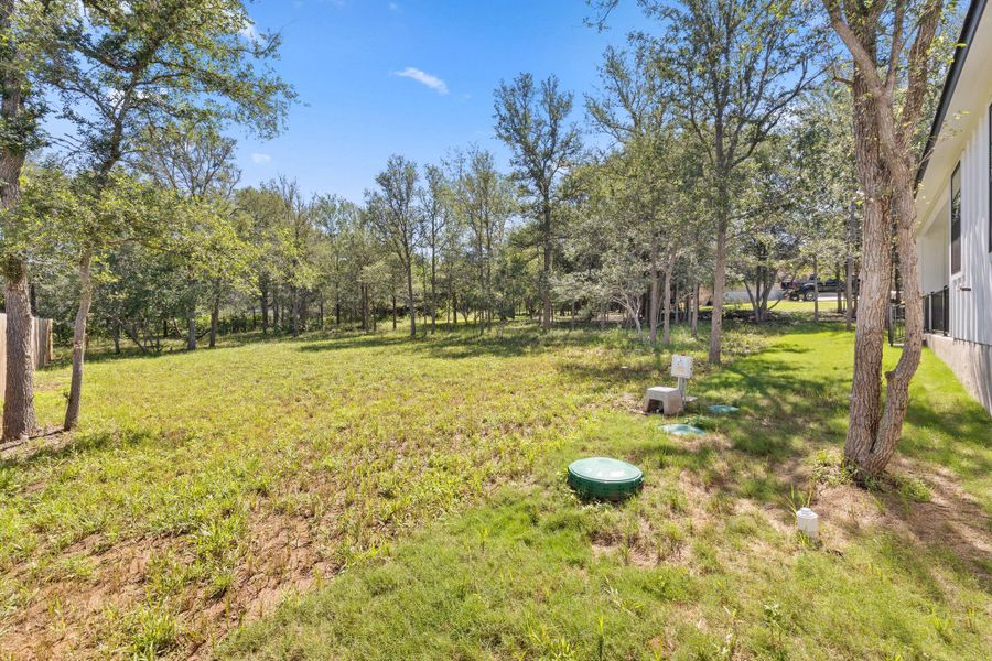 A spacious backyard with mature trees provides ample green space. A spacious backyard with mature trees provides ample green space.