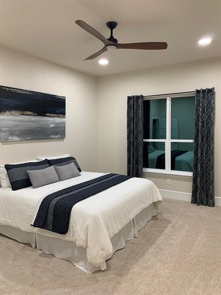 Carpeted bedroom with ceiling fan Primary