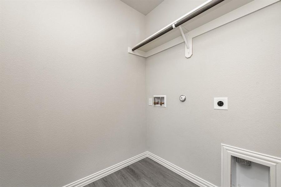 Washroom featuring electric dryer hookup, hookup for a gas dryer, hookup for a washing machine, and hardwood / wood-style floors