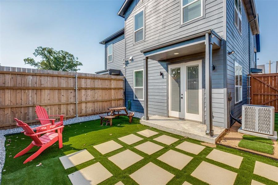 Back of property with central air condition unit, a patio area, and a yard