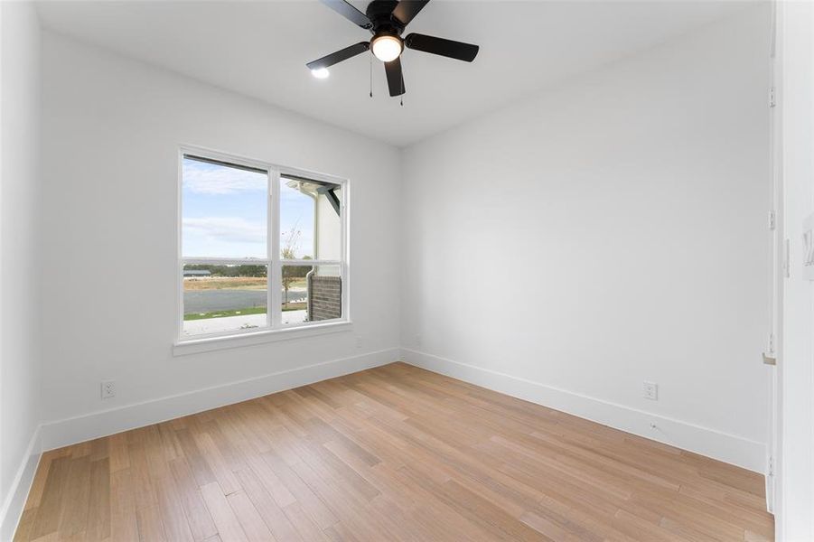 Empty room featuring light wood-style floors and a ceiling fan