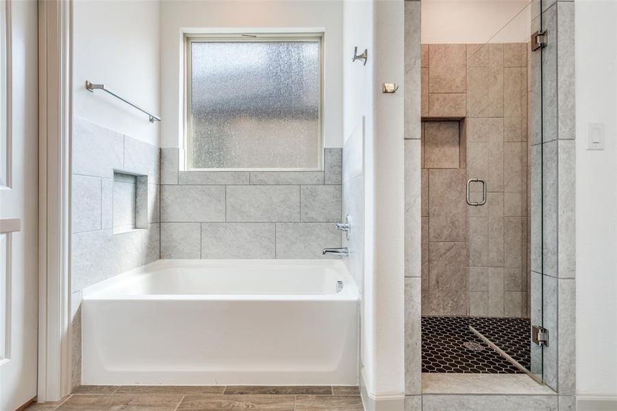 Bathroom featuring a shower stall, a garden tub, and wood tiled floors Bathroom featuring a shower stall, a garden tub, and wood tiled floors