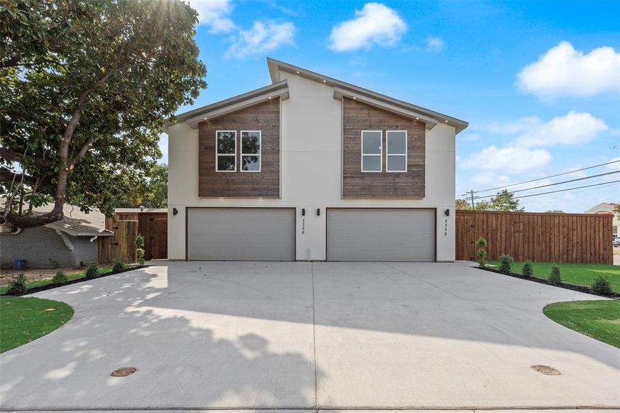 View of property exterior with a garage, concrete driveway, and stucco siding