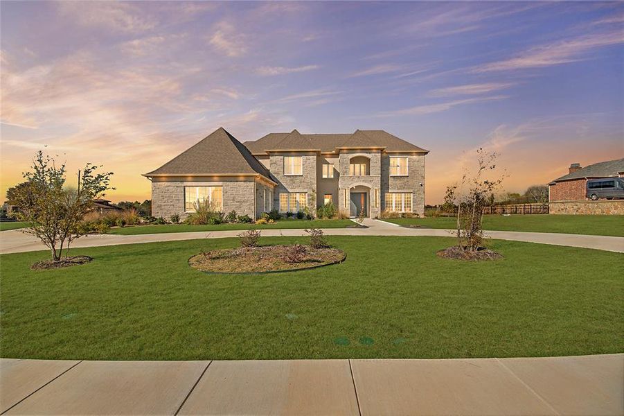 French provincial home with curved driveway, a lawn, and stone siding French provincial home with curved driveway, a lawn, and stone siding