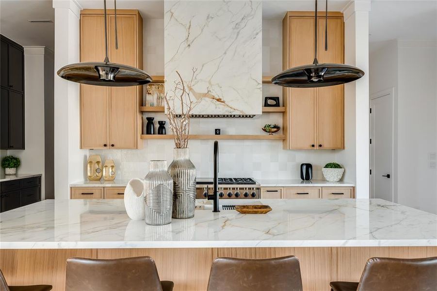 Kitchen featuring hanging light fixtures, a breakfast bar, and decorative backsplash