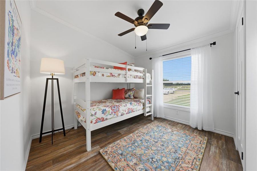 Bright room featuring wood-finish flooring, a large window with blinds, and white trim throughout