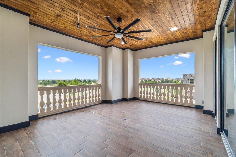 Unfurnished sunroom with ceiling fan and wood ceiling