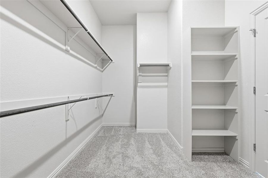Walk in closet featuring light colored carpet Walk in closet featuring light colored carpet