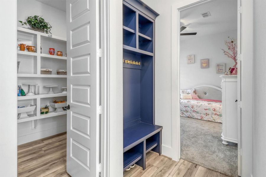 Large walk-in pantry is tucked away beside the utility room. A built-in mudroom bench features cubbies and hooks, the perfect catch-all when you're coming in from the garage. Second downstairs bedroom is straight ahead.