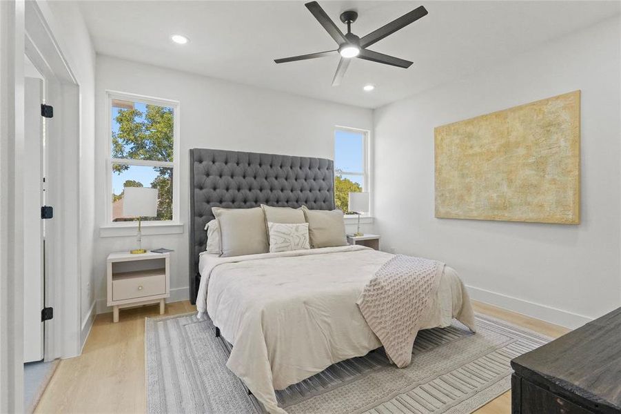 Bedroom featuring light wood-type flooring, recessed lighting, and a ceiling fan Bedroom featuring light wood-type flooring, recessed lighting, and a ceiling fan