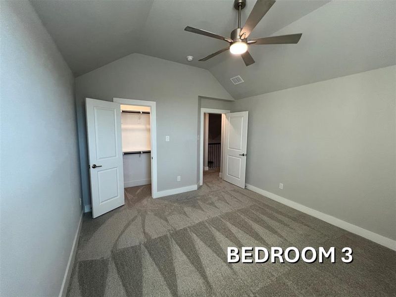 Carpeted room featuring a vaulted ceiling, a contemporary ceiling fan with integrated lighting, and a closet with shelving Carpeted room featuring a vaulted ceiling, a contemporary ceiling fan with integrated lighting, and a closet with shelving