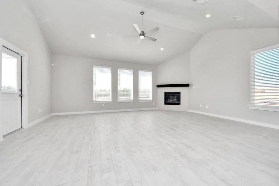 Welcome family and guests to your charming living room! With its high ceilings, recessed lighting, ceiling fan, custom paint, beautiful flooring, and large windows that let in abundant natural light, this room is perfect for gatherings. Sample photo of completed home with similar floor plan. Actual colors and selections may vary.