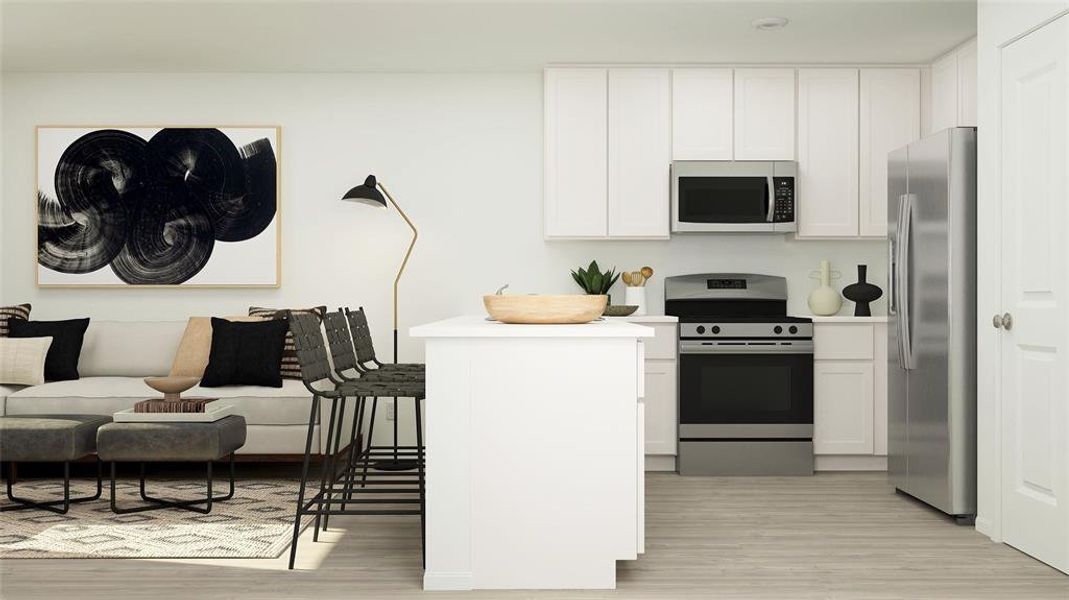 Kitchen featuring appliances with stainless steel finishes, light hardwood / wood-style floors, and white cabinetry