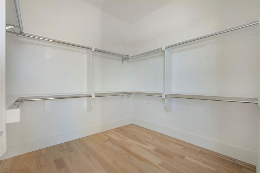 Walk in closet with wood-type flooring