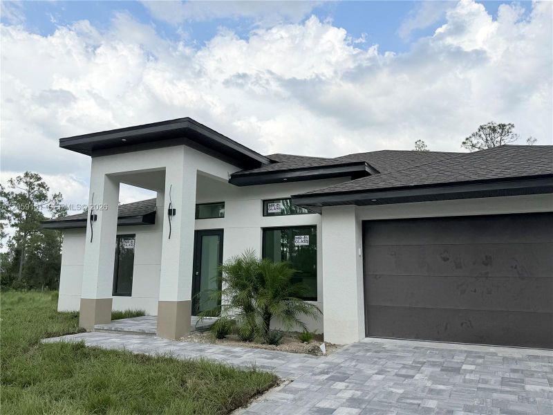 Front exterior of a new home in , Lehigh Acres, FL, highlighting curb appeal (Image 21).