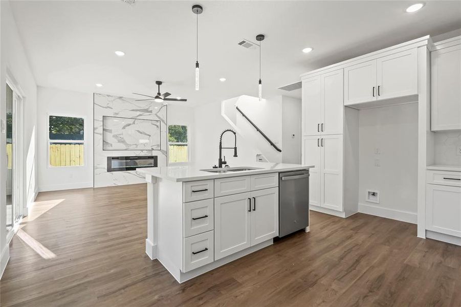 Kitchen featuring a high end fireplace, white cabinets, recessed lighting, dark wood-type flooring, and healthy amount of natural light