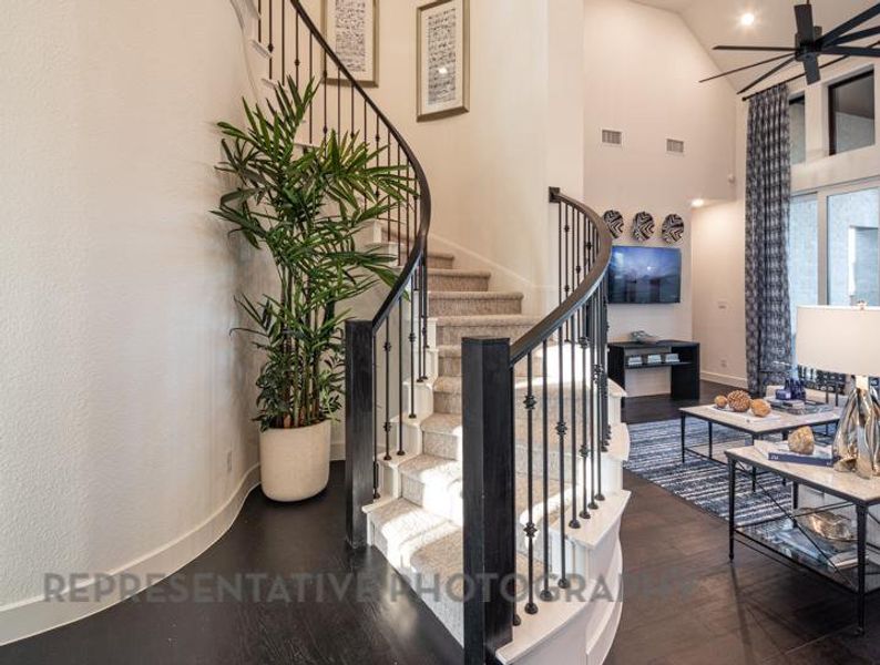 Stairway with wood finished floors, high vaulted ceiling, and ceiling fan Stairway with wood finished floors, high vaulted ceiling, and ceiling fan