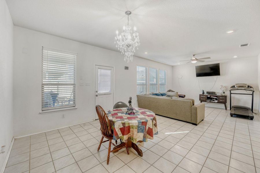 Dining area with ceiling fan, light tile patterned floors, recessed lighting, and a chandelier