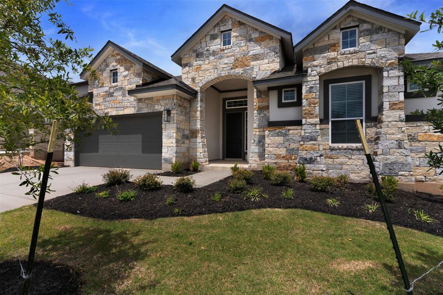 Stone veneer exterior featuring multiple gables and dark trim accents Stone veneer exterior featuring multiple gables and dark trim accents