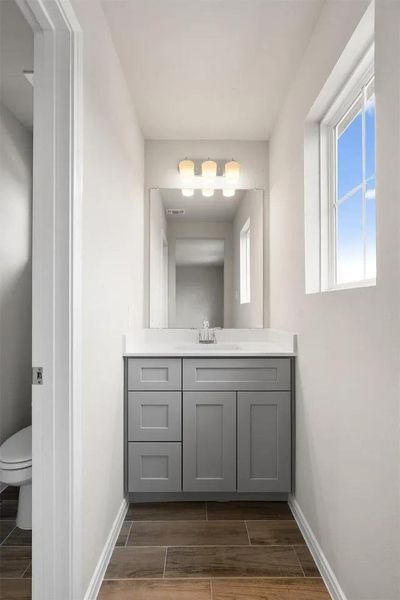 A well-appointed lavatory boasts a pristine vanity and abundant ambient light.