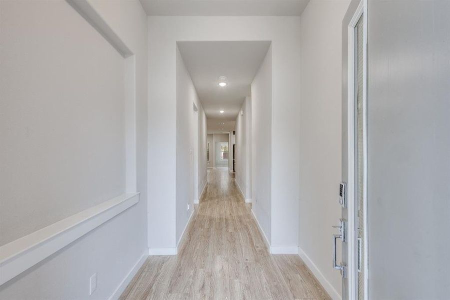 Corridor with light wood-type flooring and recessed lighting Corridor with light wood-type flooring and recessed lighting