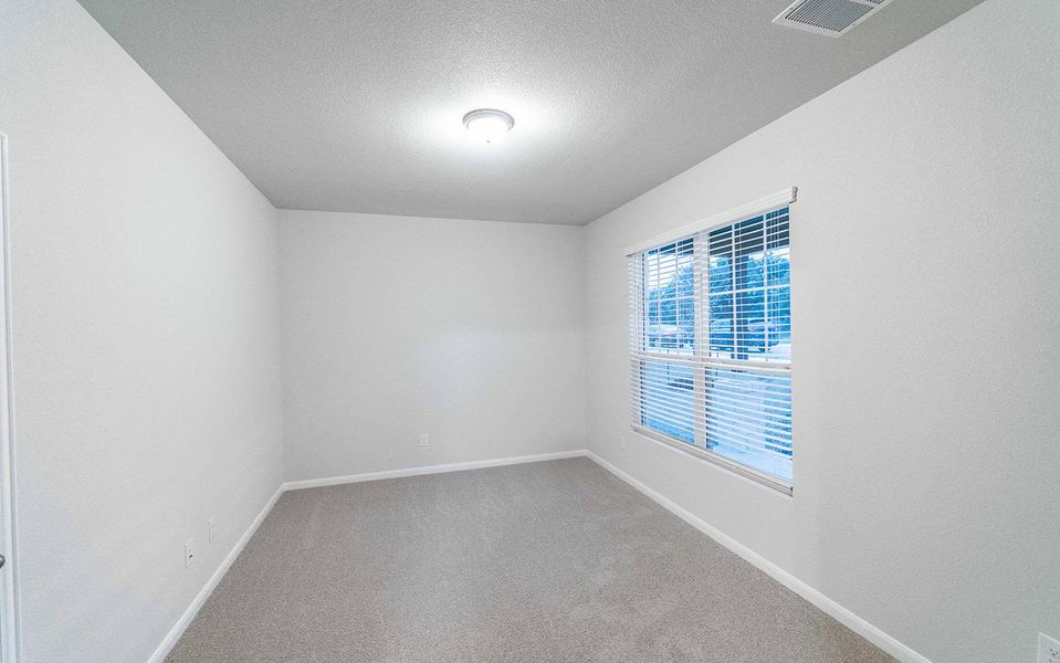 Carpeted empty room with visible vents, a textured ceiling, and baseboards