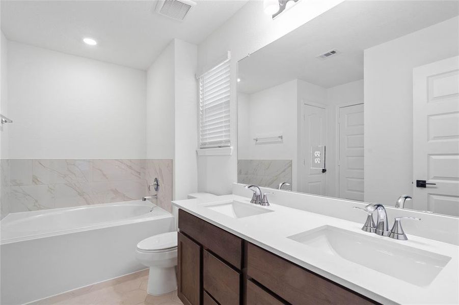 This primary bathroom is definitely move-in ready! Featuring an oversized soaking tub with tile, walk-in shower with tile surround, stained cabinets with light countertops and dual vanities, high ceilings, neutral paint, sleek and modern finishes.