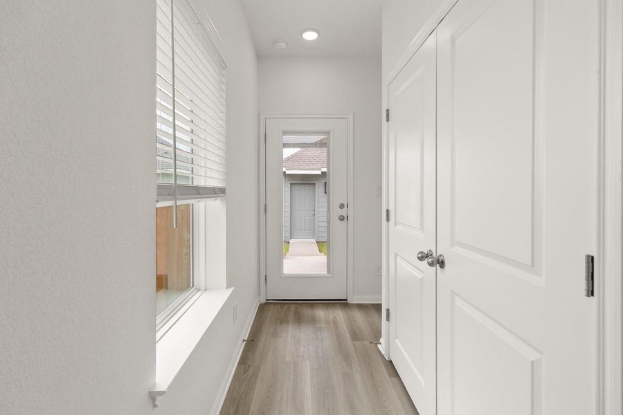 Corridor featuring light wood-type flooring and baseboards