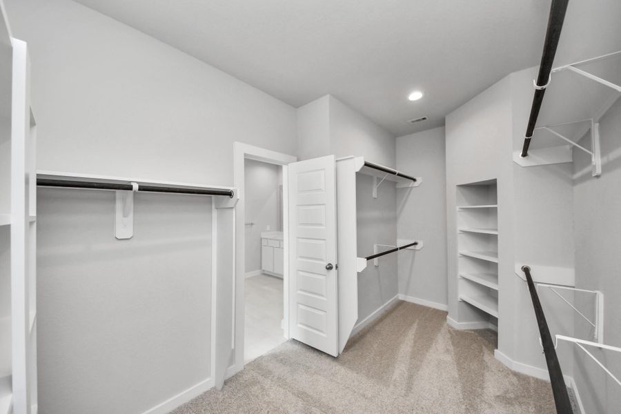 Walk-in closet that epitomizes luxury and practicality. This generously sized space features built-in shelving, offering abundant room for impeccable organization. High ceilings and recessed lighting create a bright and welcoming ambiance. Sample photo of completed home with similar floor plan. Actual colors and selections may vary. Walk-in closet that epitomizes luxury and practicality. This generously sized space features built-in shelving, offering abundant room for impeccable organization. High ceilings and recessed lighting create a bright and welcoming ambiance. Sample photo of completed home with similar floor plan. Actual colors and selections may vary.
