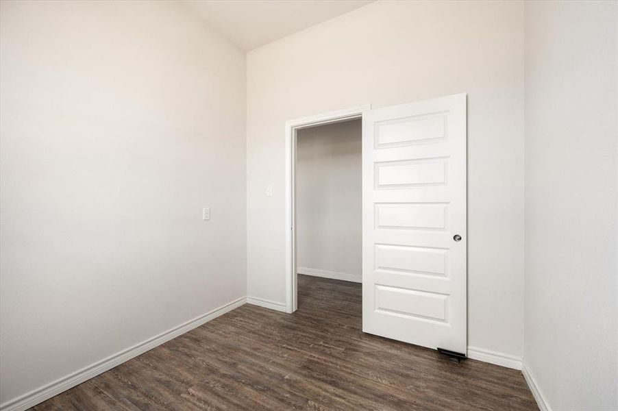 Unfurnished bedroom with dark hardwood / wood-style flooring and a closet