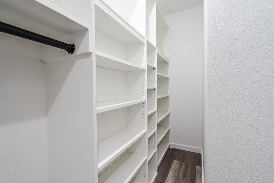 Customizable shelving and hanging space offer organized storage in this walk-in wardrobe. Customizable shelving and hanging space offer organized storage in this walk-in wardrobe.