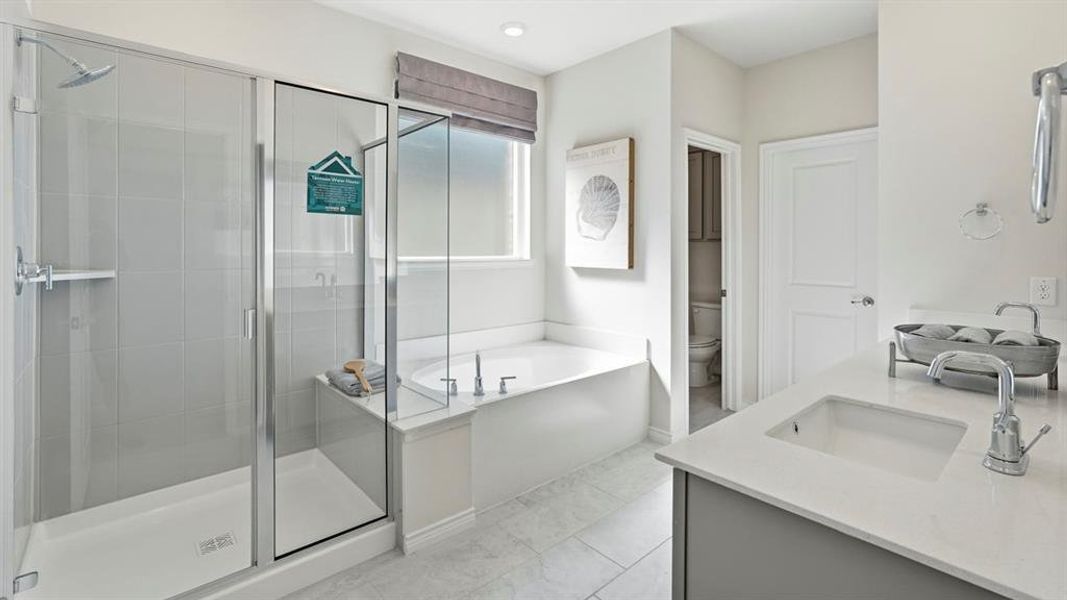 Full bathroom featuring double vanity, a stall shower, and a bath