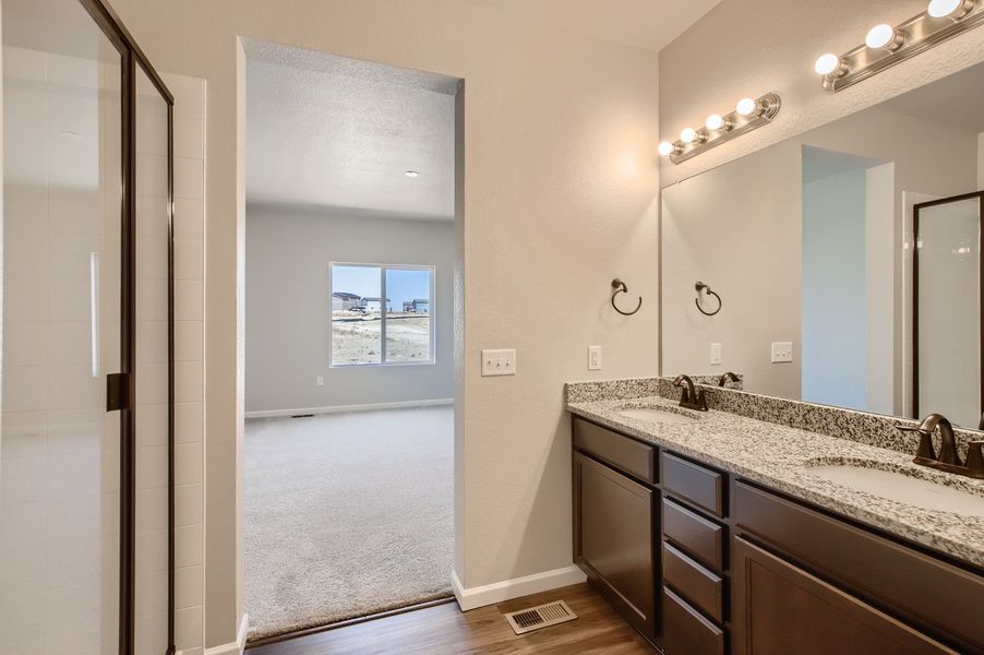 Owner's dual vanity and shower of the ranch style Telluride plan by Century Communities