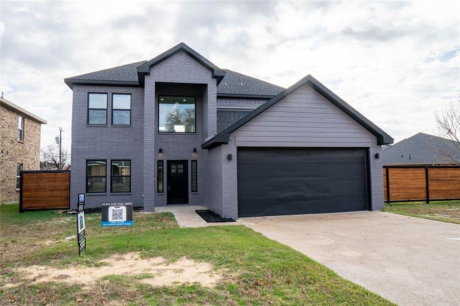 View of front of property with a garage and a front yard