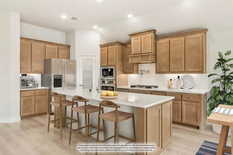 Kitchen with honey-toned wood cabinets, center island with seating, stainless appliances, and light hardwood floors Kitchen with honey-toned wood cabinets, center island with seating, stainless appliances, and light hardwood floors