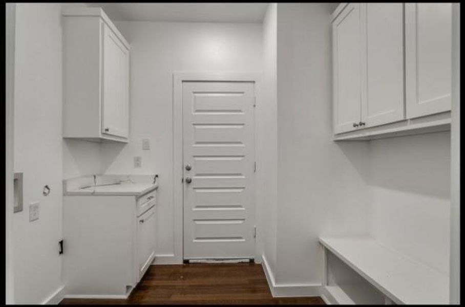 Laundry room featuring dark wood-type flooring