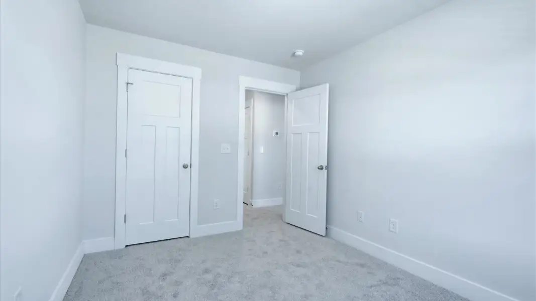 Superior comfort in a secondary bedroom with plush carpet and an spacious walk-in closet by DRB Homes