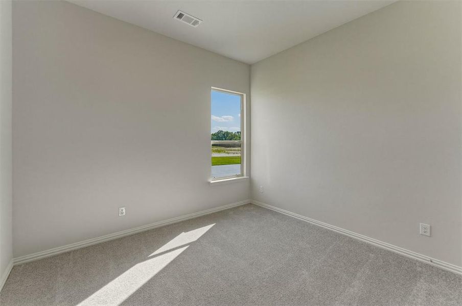 Room with light gray walls, white trim, and gray carpeted flooring Room with light gray walls, white trim, and gray carpeted flooring