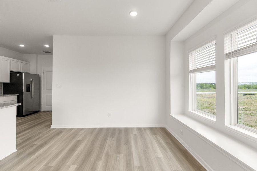 Unfurnished dining area with light wood-style floors and recessed lighting