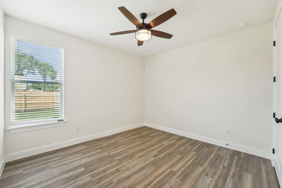 Bedroom 3 featuring ceiling fan, baseboards, wood-style vinyl flooring, and plenty of natural light Bedroom 3 featuring ceiling fan, baseboards, wood-style vinyl flooring, and plenty of natural light