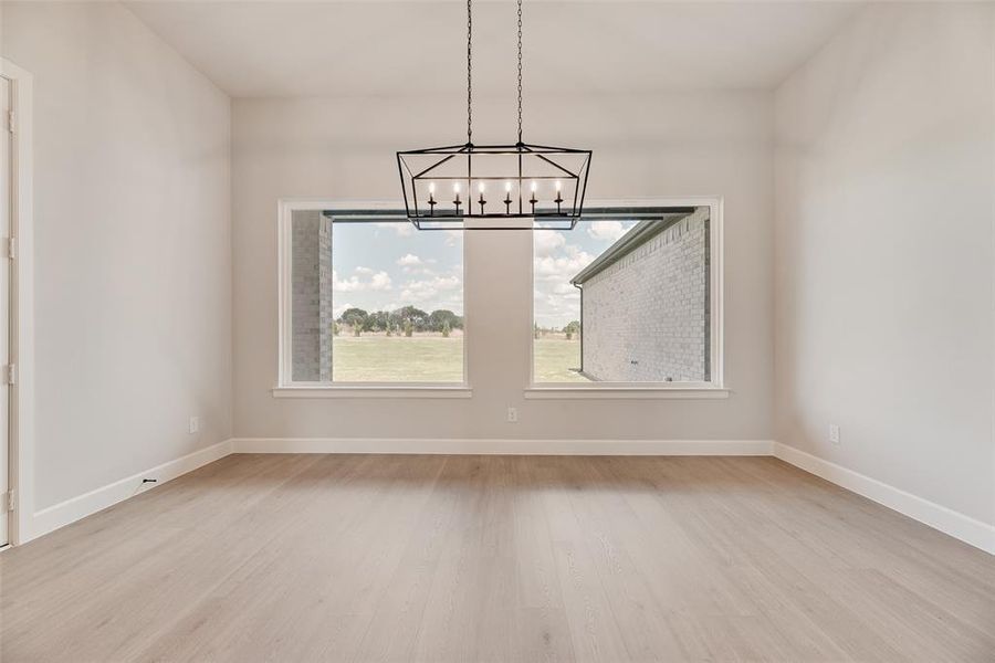 Unfurnished dining area with light wood-type flooring and a chandelier