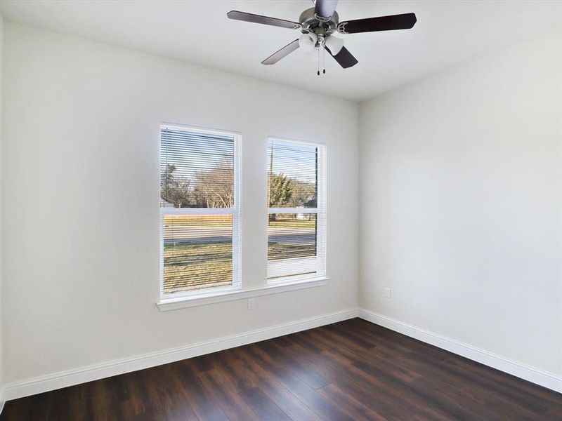 Spare room with a ceiling fan and dark wood finished floors Spare room with a ceiling fan and dark wood finished floors