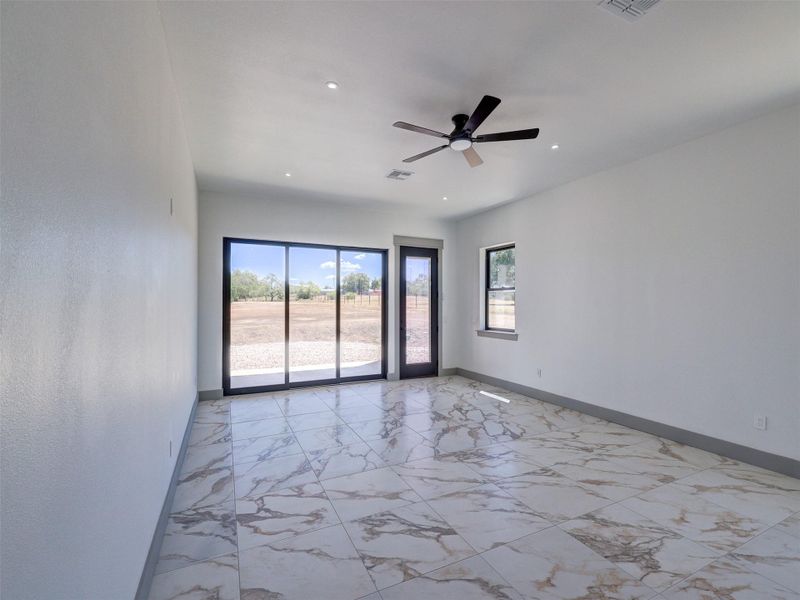 Polished tile flooring and expansive sliding glass doors define this open, airy living space.