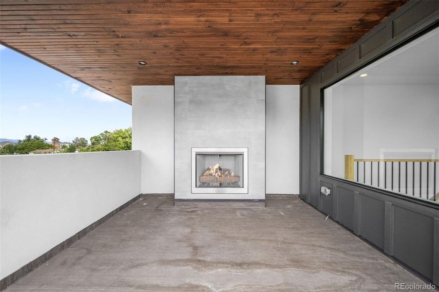 Large partially covered rooftop with fireplace