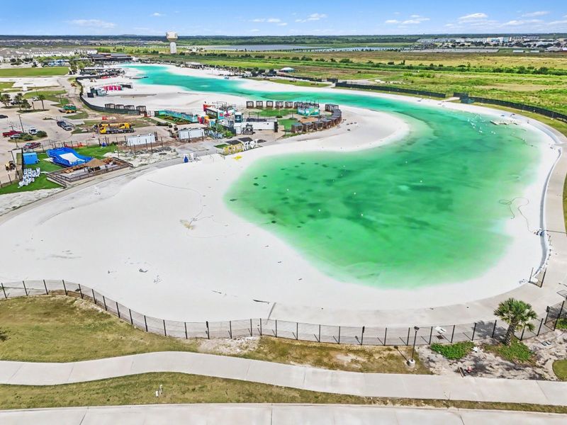 Aerial view of the crystal lagoon showcasing expansive waterfront areas, sandy beaches, and community gathering spaces. Aerial view of the crystal lagoon showcasing expansive waterfront areas, sandy beaches, and community gathering spaces.