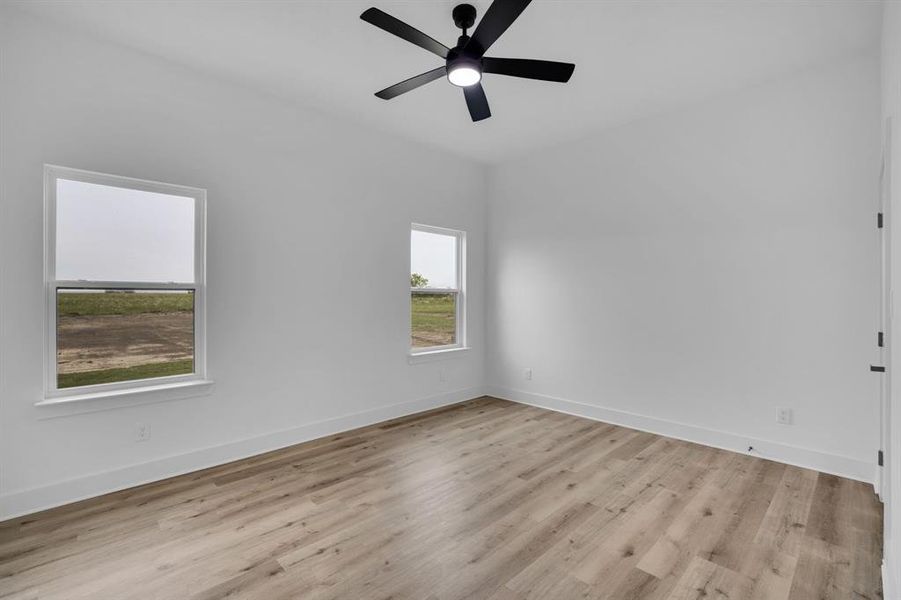 Empty room featuring light hardwood / wood-style flooring and ceiling fan