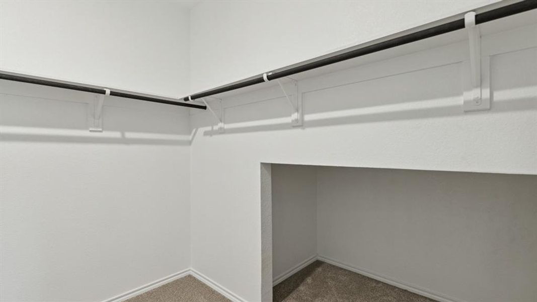 Walk in closet with dark carpet
